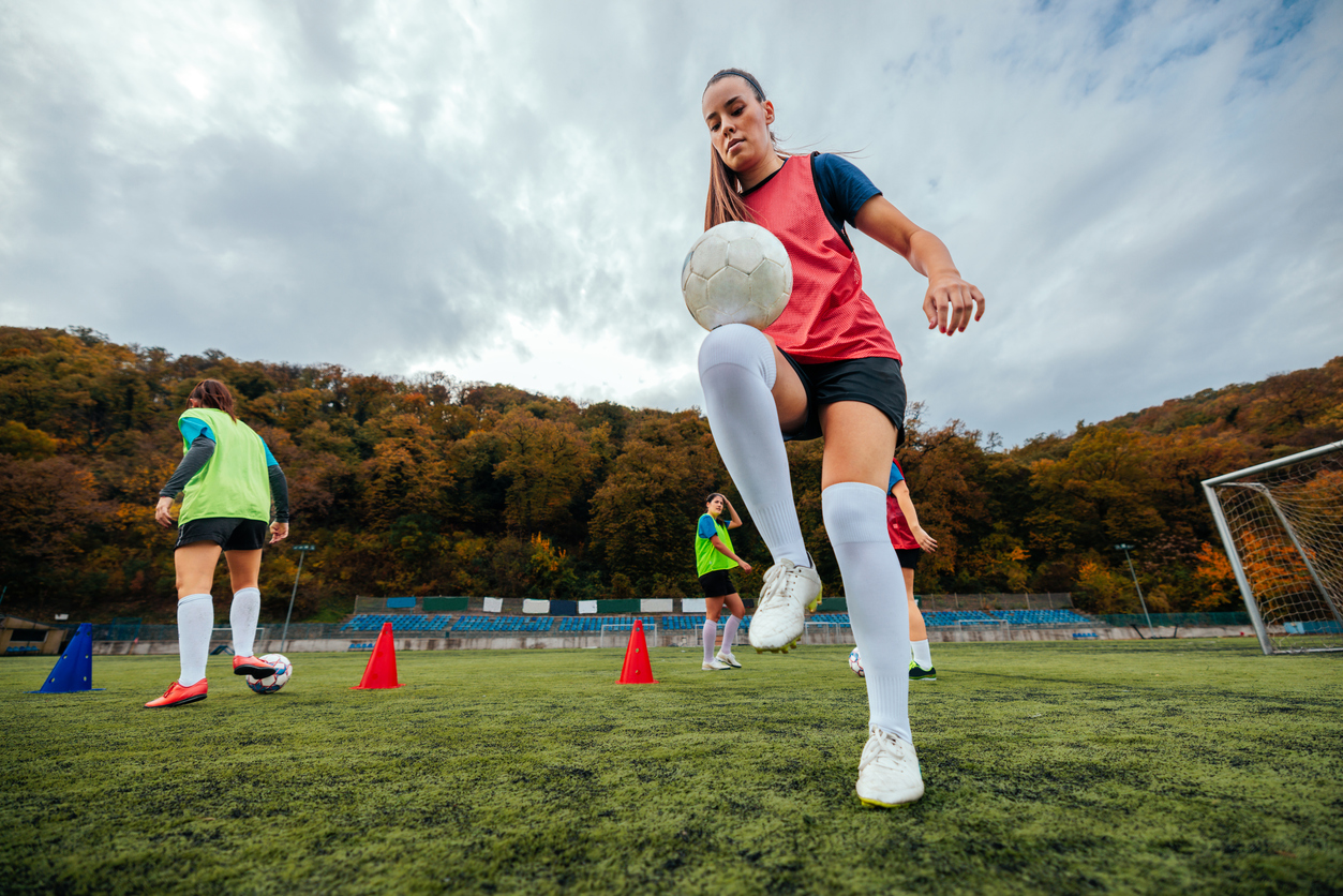 woman playing soccer outdoors