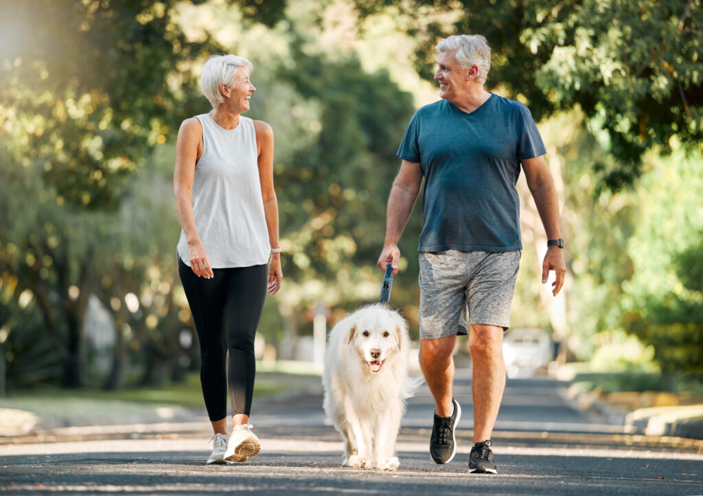 Older woman and man walking dog for exercise