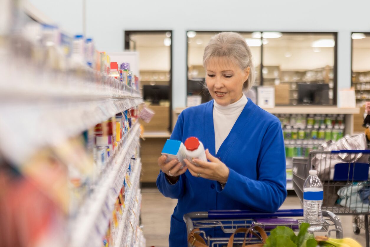woman in pharmacy looking at bottles