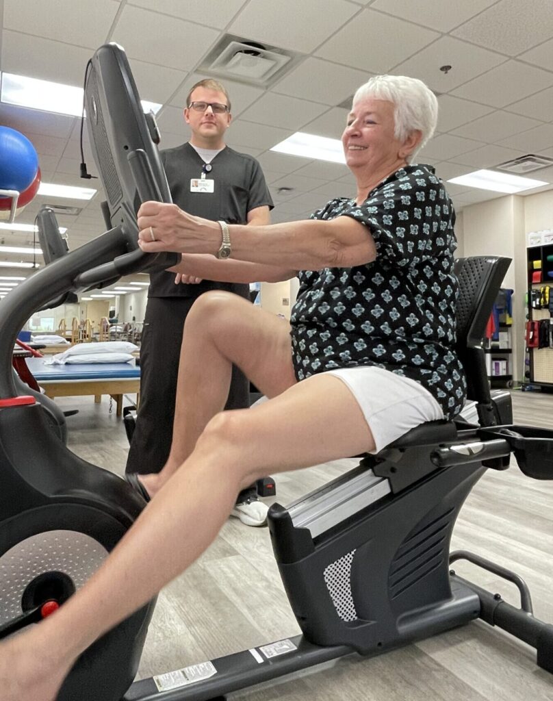 Physical therapist Brad Davis monitors Dawn Shiroda on exercise bike at Covenant Health Therapy Center - Tazewell