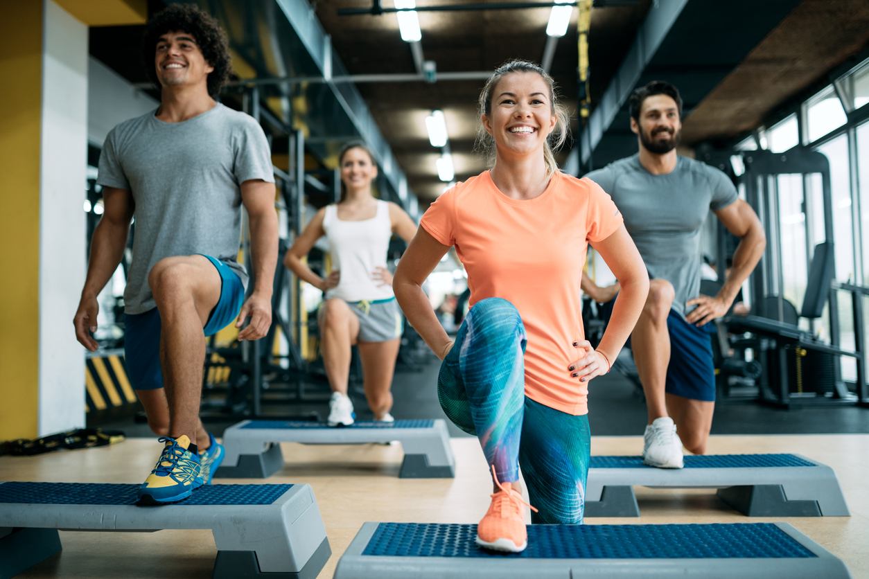 Group of young people doing exercises together in gym.