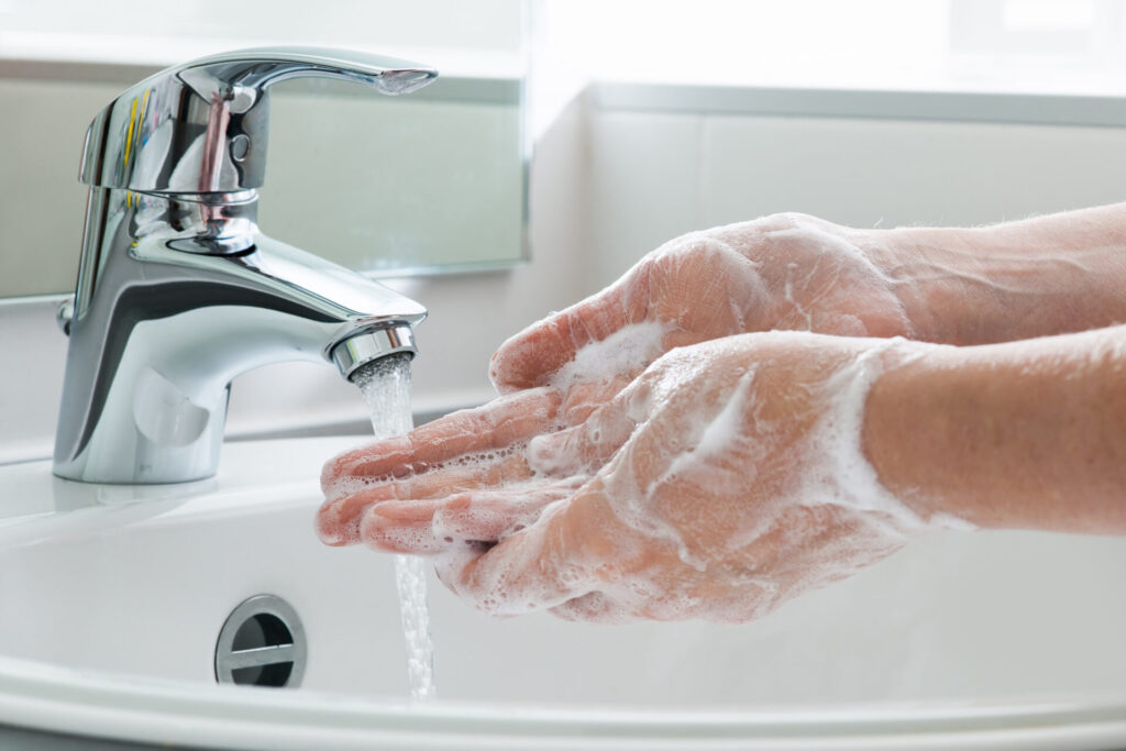 Soapy hands under 1facet with running water