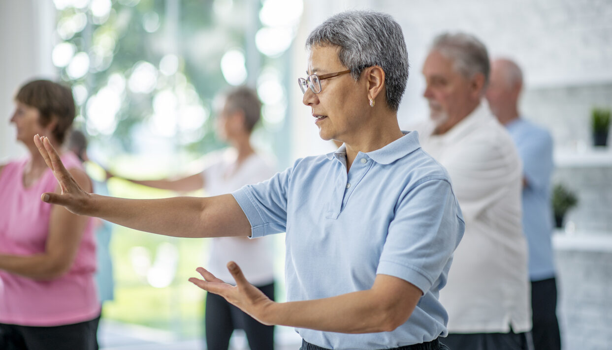 A group of seniors take a Qi Gong fitness together at the gym.