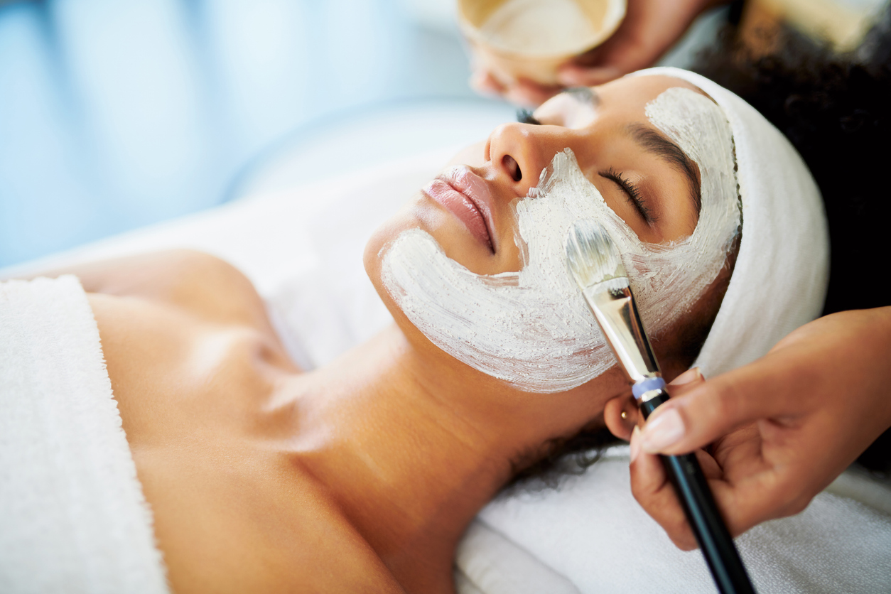 Young woman getting a facial at a beauty spa.
