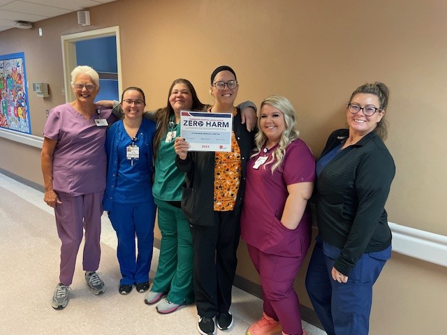 Photo of six standing female staff members, one is holding Zero Harm recognition certificate