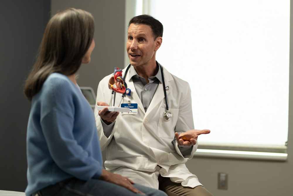 A Covenant Health cardiologist discusses options with a patient in a physician's office.