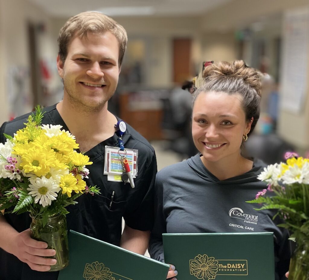 Smiling nurses holding daisies