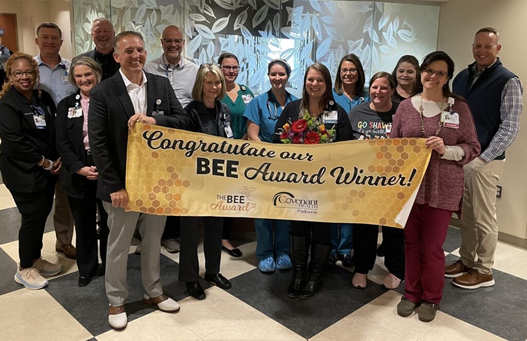 Group of medical workers with BEE Award banner.