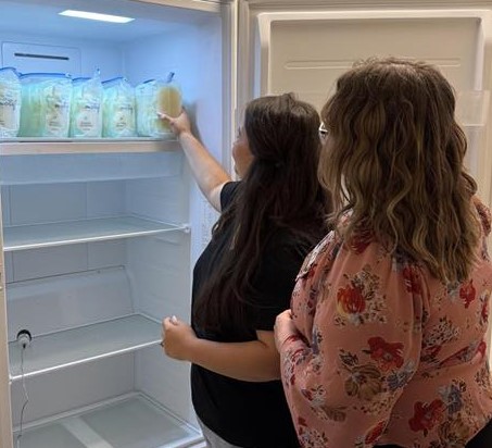 Two women at refrigerator donating breast milk