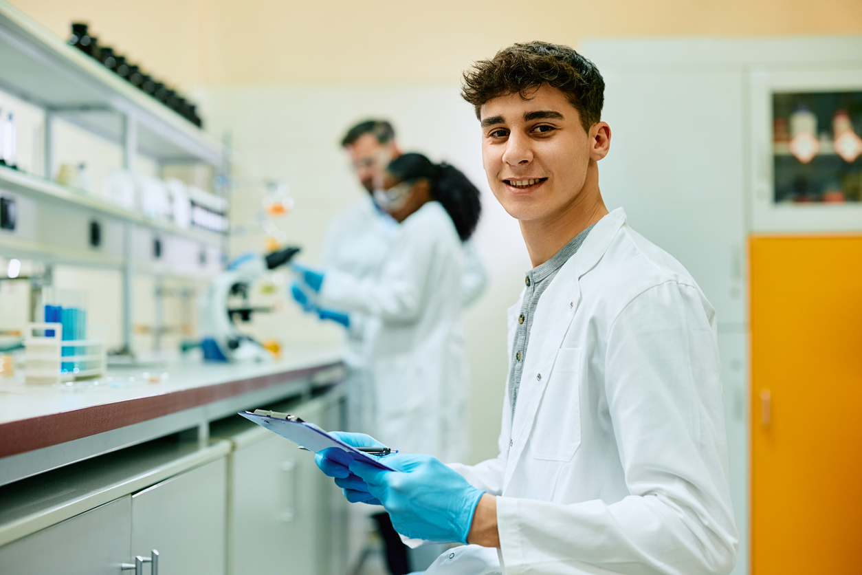 young male student in white coat in medical setting