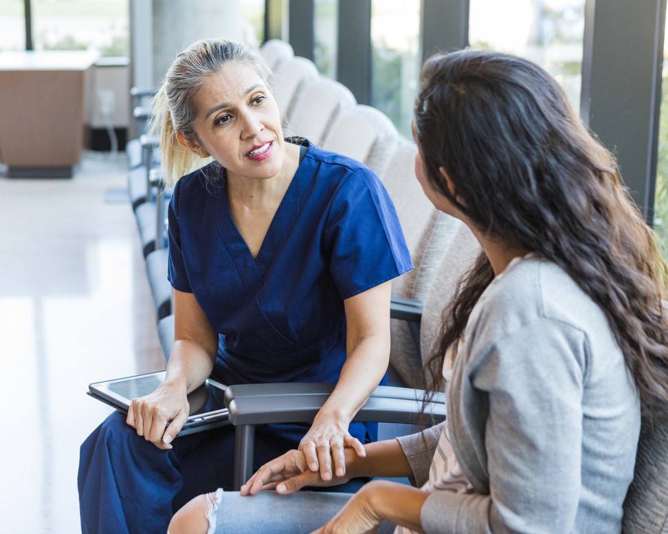Triage nurse comforts woman waiting in ED
