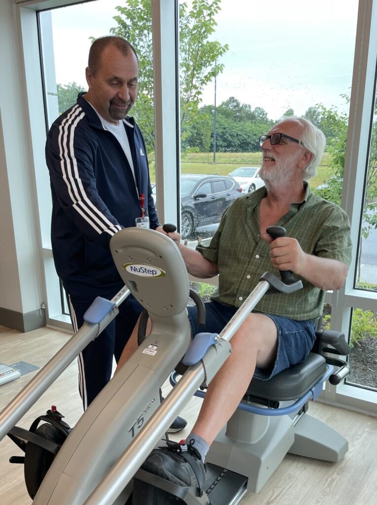 Kim Arnott rides an exercise bike while being supervised by Chris Spruiell, supervisor of cardiac rehab