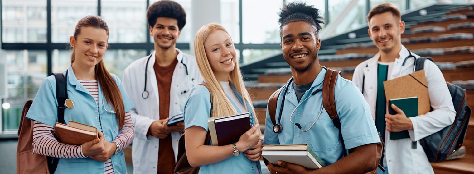two female and three male high school students in scrubs with textbooks
