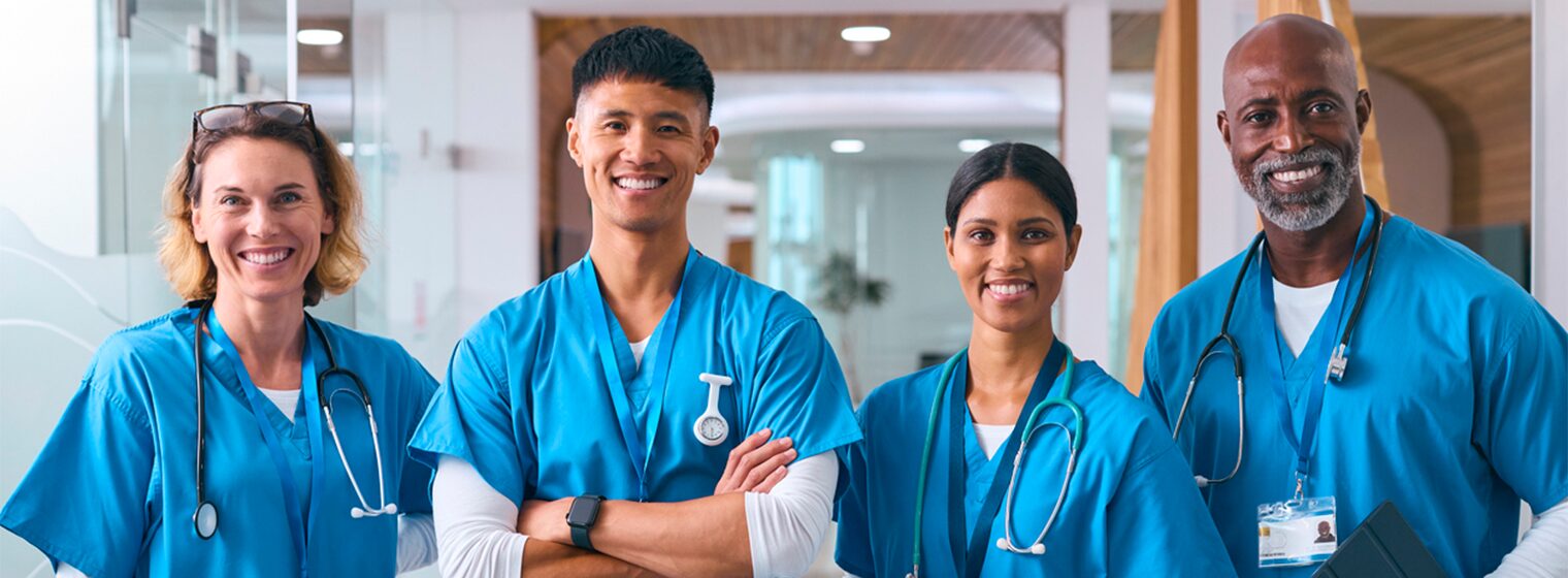 two female and two male medical staff in scrubs smiling