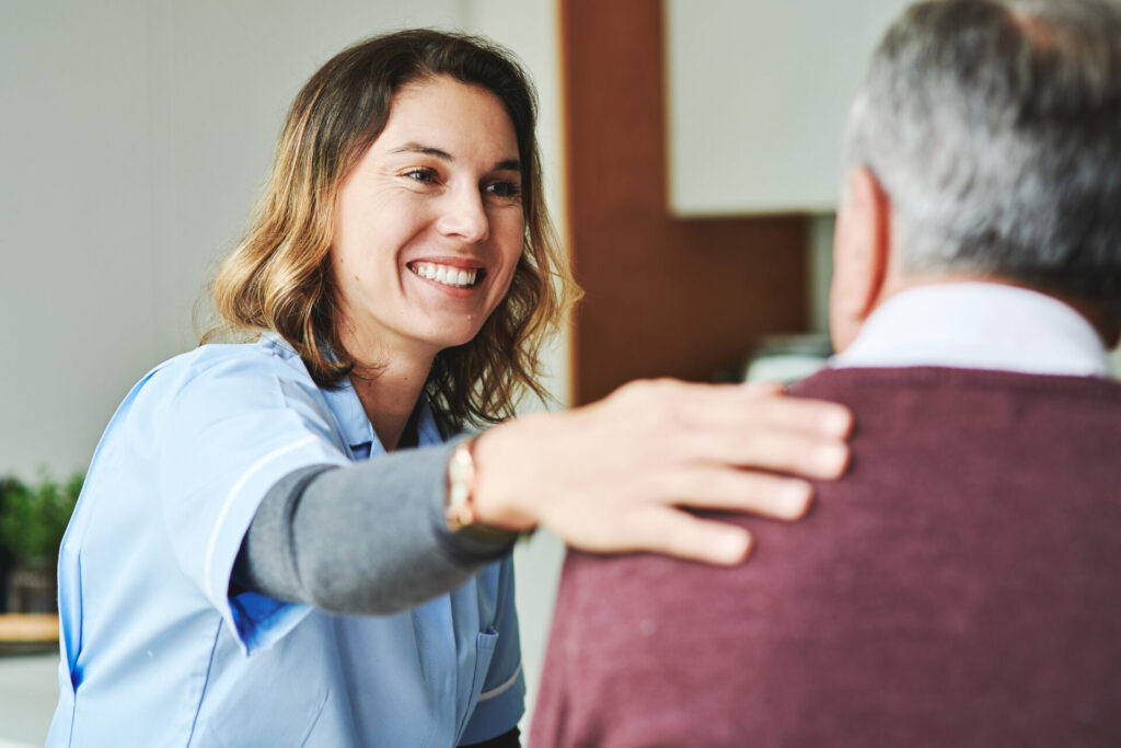 Adult female healthcare worker with elderly male patient.