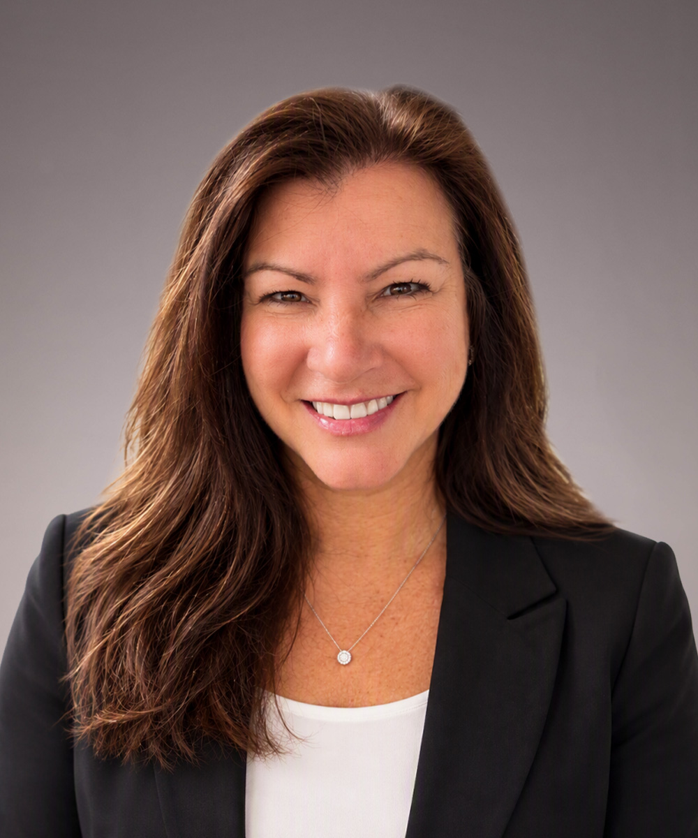 Headshot of Cheryl Wild, a smiling woman wearing a black blazer over a white shirt.
